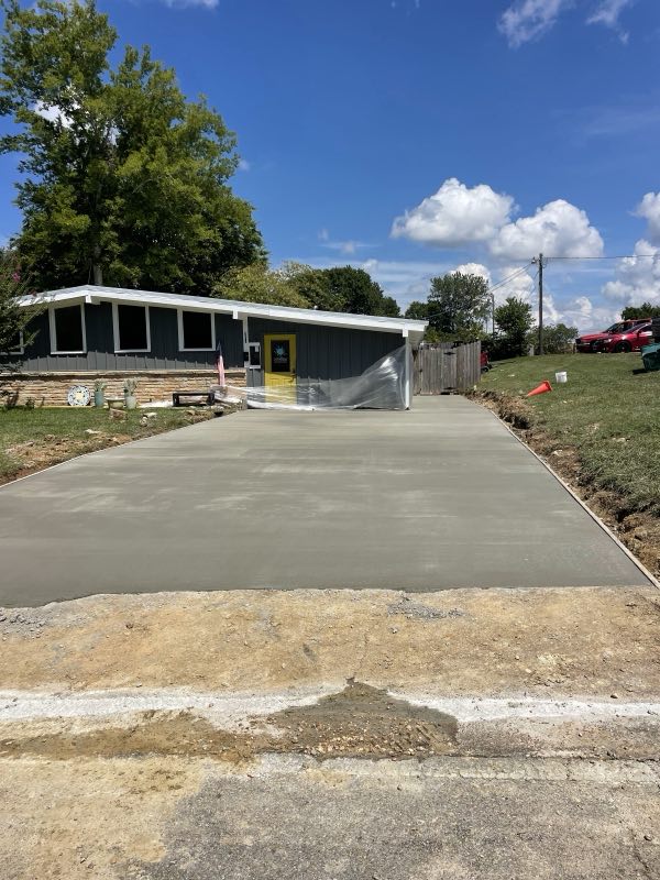 Wide finished concrete driveway leading up to a home